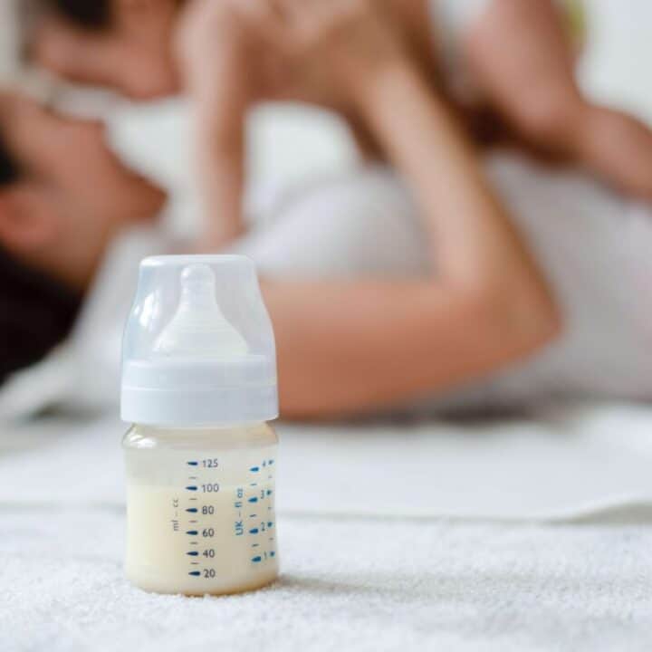Mother holding baby with bottle of formula in the foreground