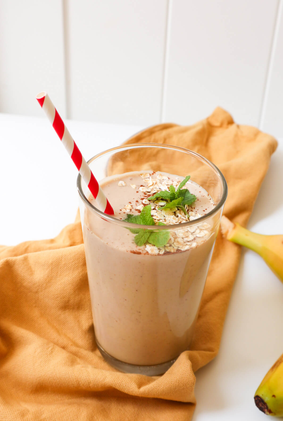 smoothie in a glass on. a brown kitchen towel 