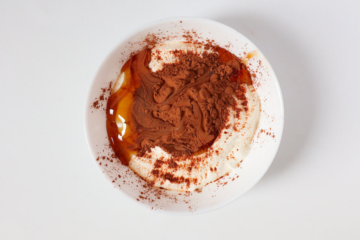 Yogurt with cacao powder in a bowl.