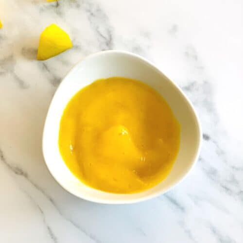 mango puree for baby in a white bowl