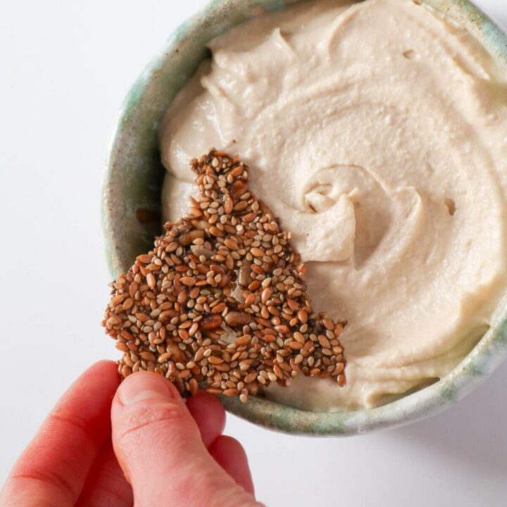 Sunflower Sesame Seed Crackers dipped in hummus.