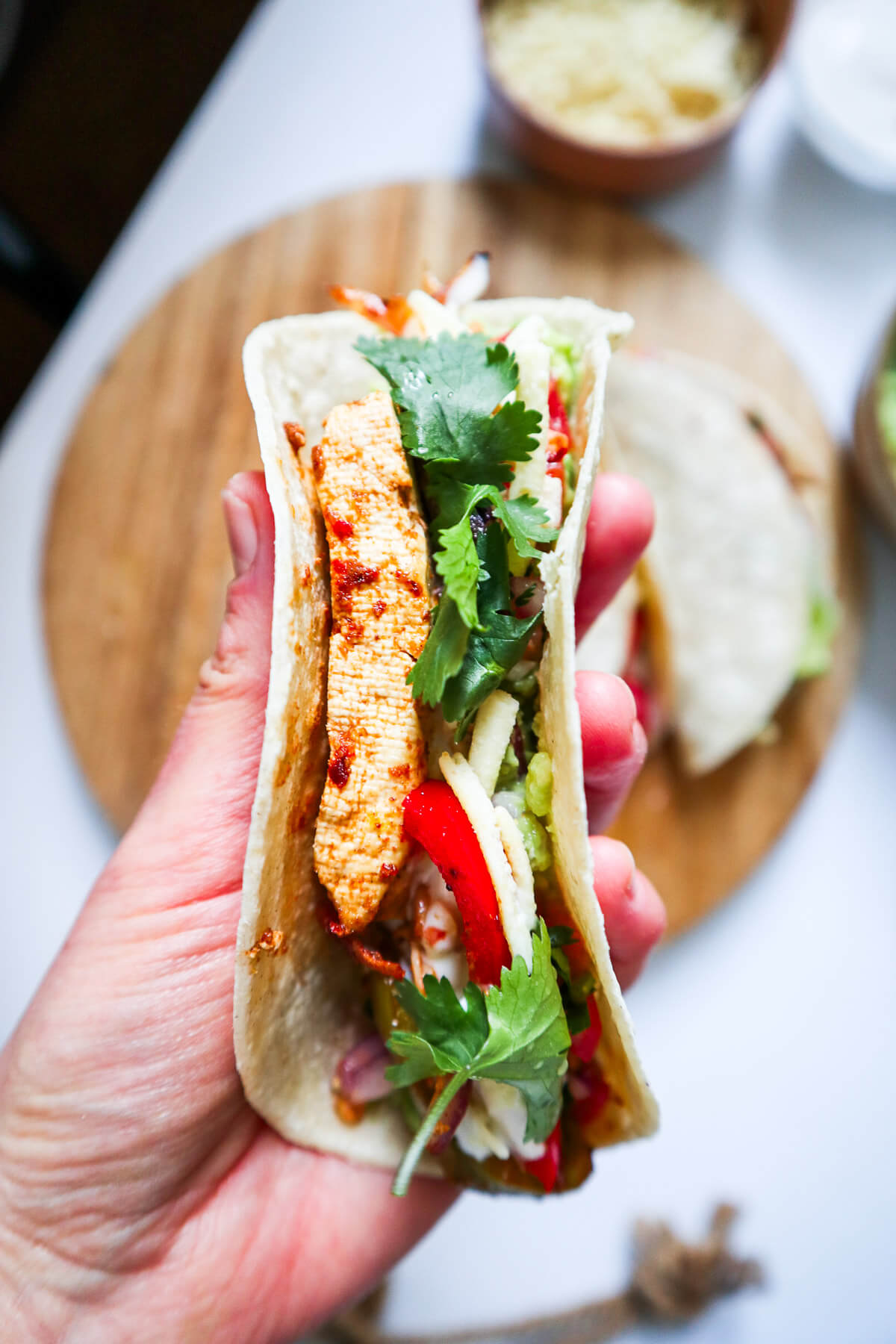 Tofu fajita folded and held by hand