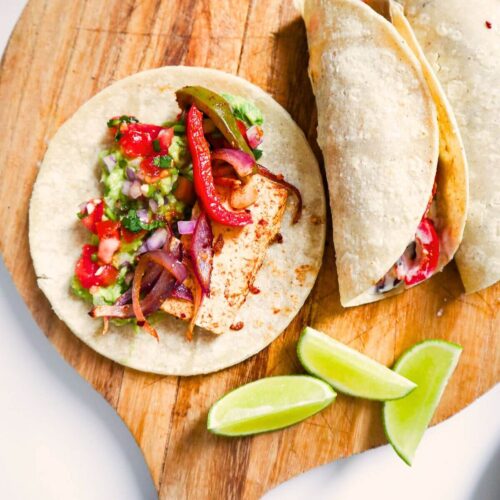 Fajitas on a wooden board with limes