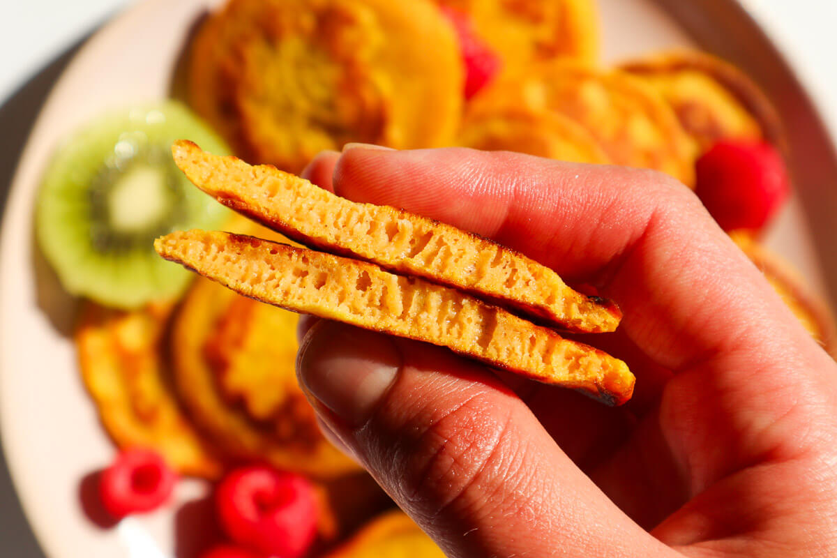 Hand holding a halved sweet potato pancake