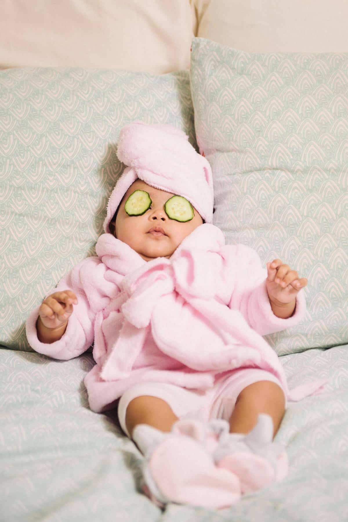 Baby relaxing in a pink bathrobe in bed