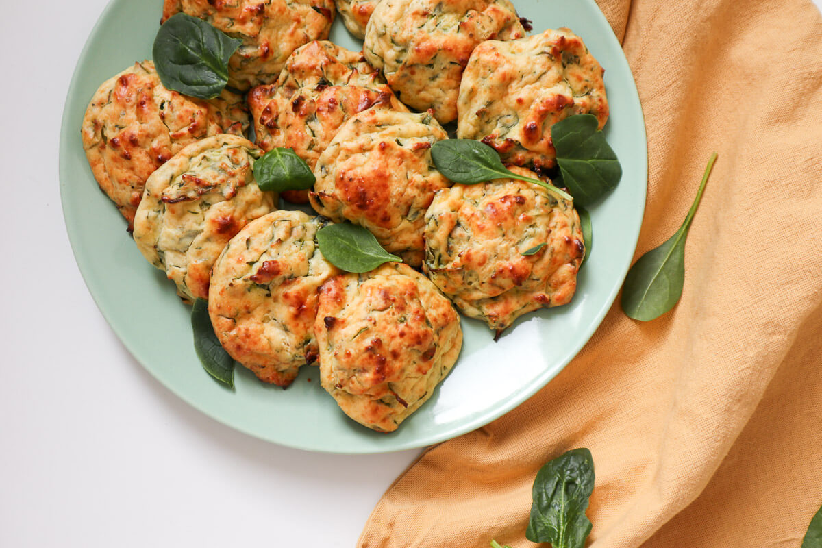 Baked Spinach and Ricotta Patties on a plate with a yellow kitchen towel on the side.