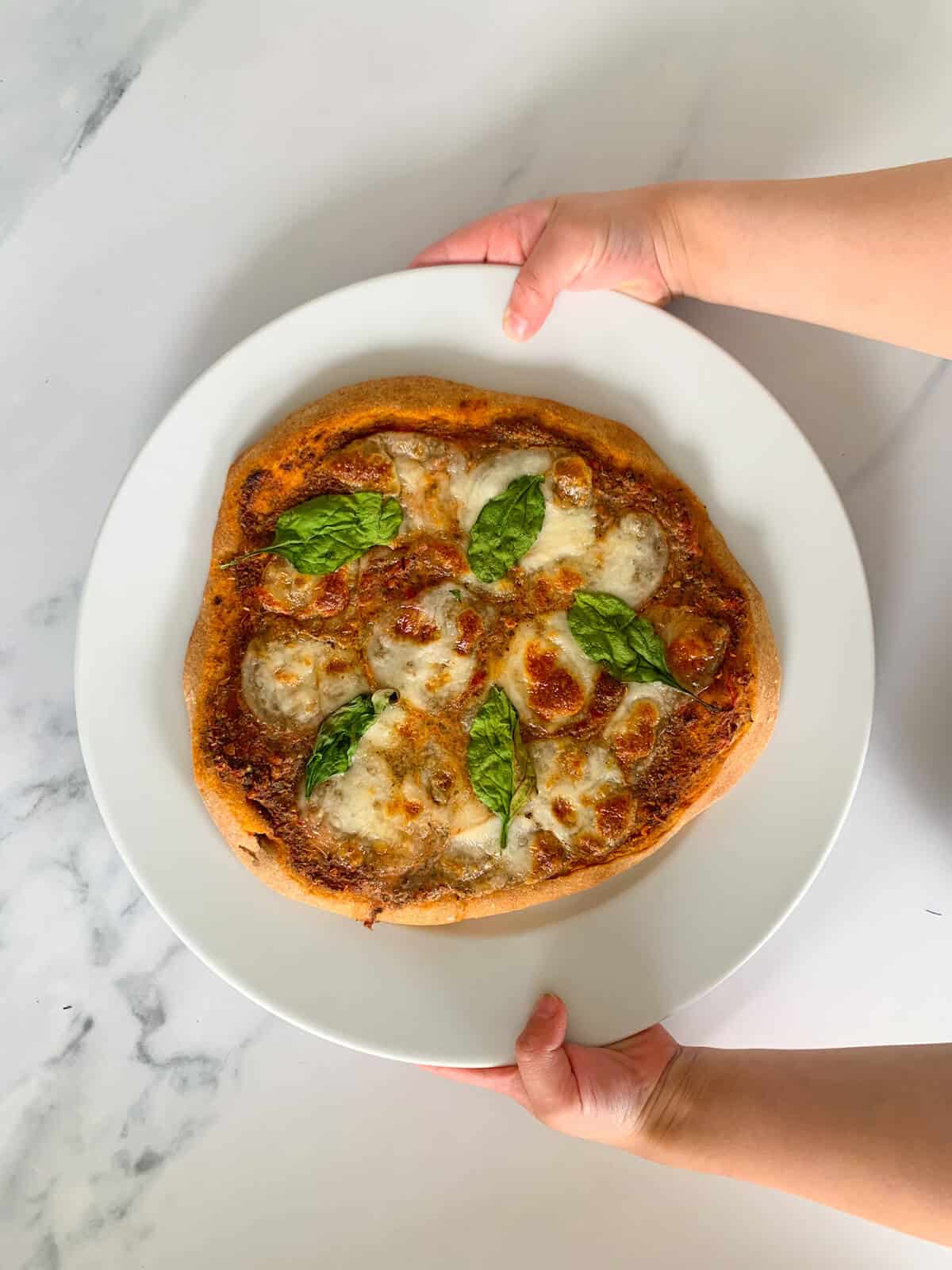 toddler holding pizza