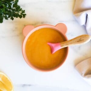 red lentil soup for baby in a silicone baby bowl with spoon