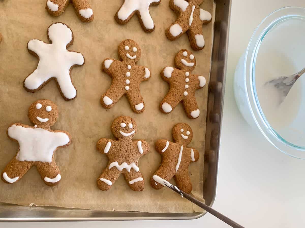 Kids decorating cookies with a chopstick using royal icing