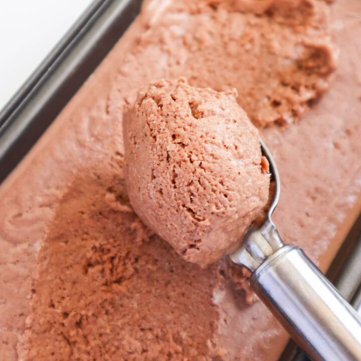 ice cream scoop scooping out ice cream from a tub