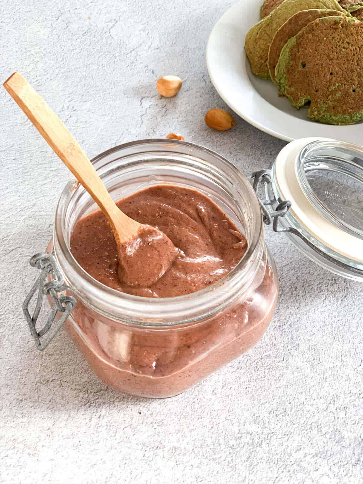 Homemade vegan nutella with dates in a jar with a wooden spoon 