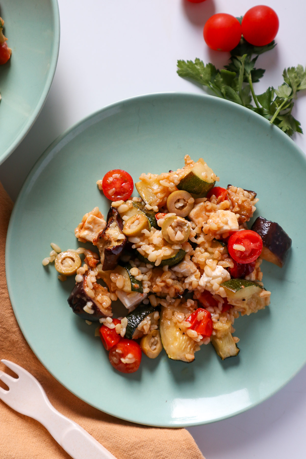 Summer salad with bulgur, roasted veg and feta on a plate.