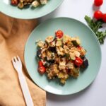 Summer salad with bulgur, roasted veg and feta on a plate.