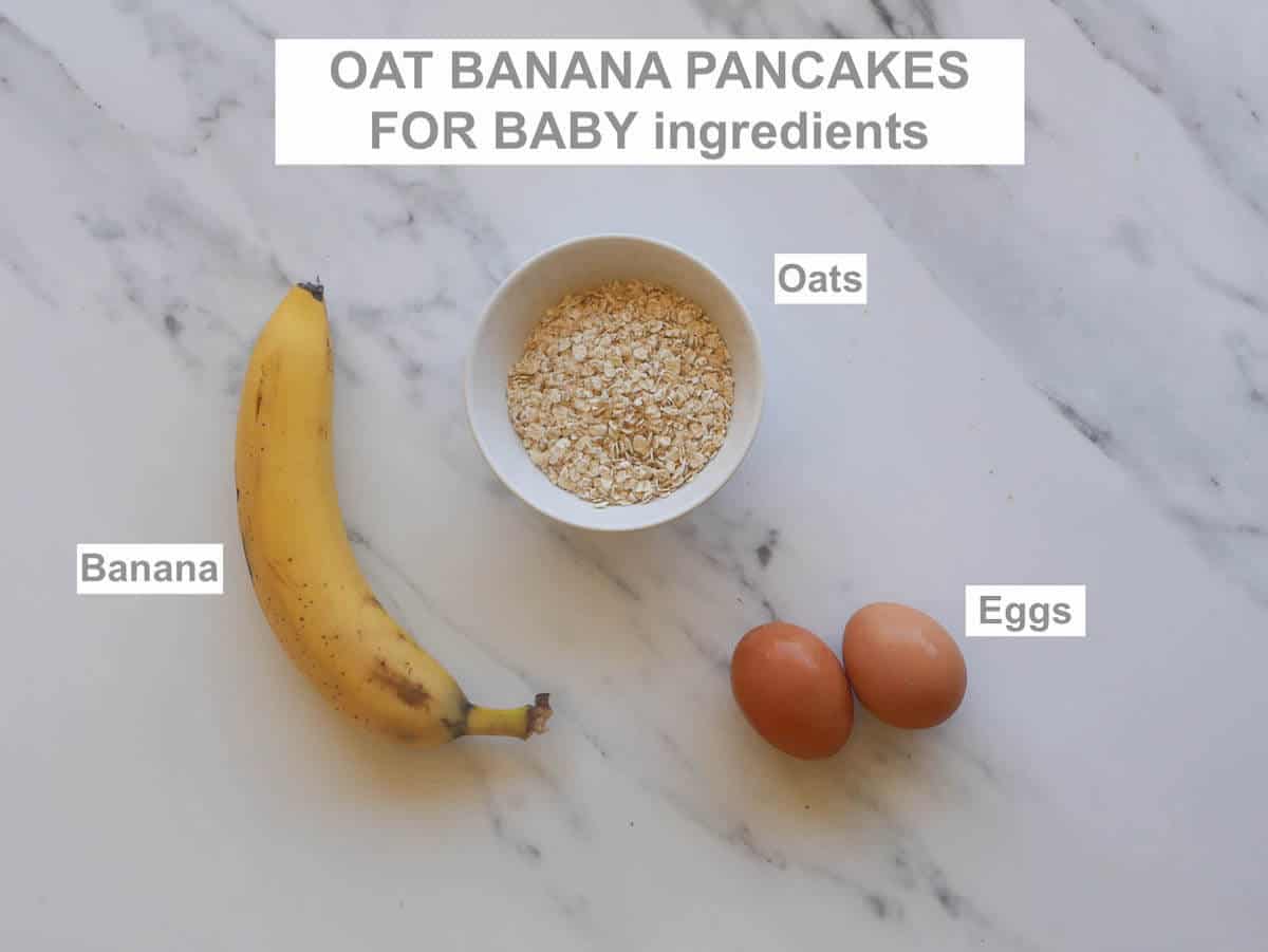 ingredients on a marble background - banana, 2 eggs, bowl of oats