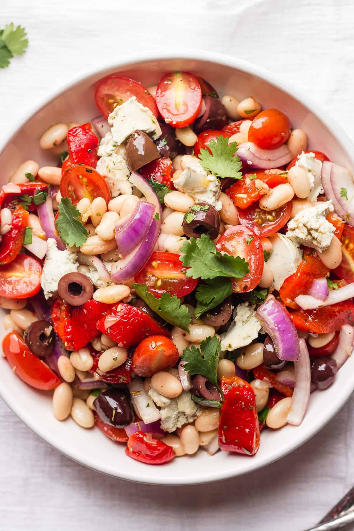 canellini bean salad with olives and cashew cheese in a bowl 