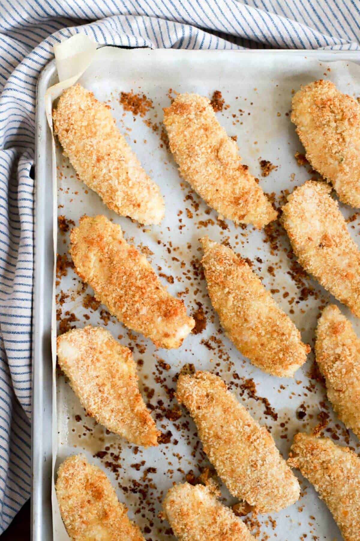 Baked chicken tenders on parchment paper. 