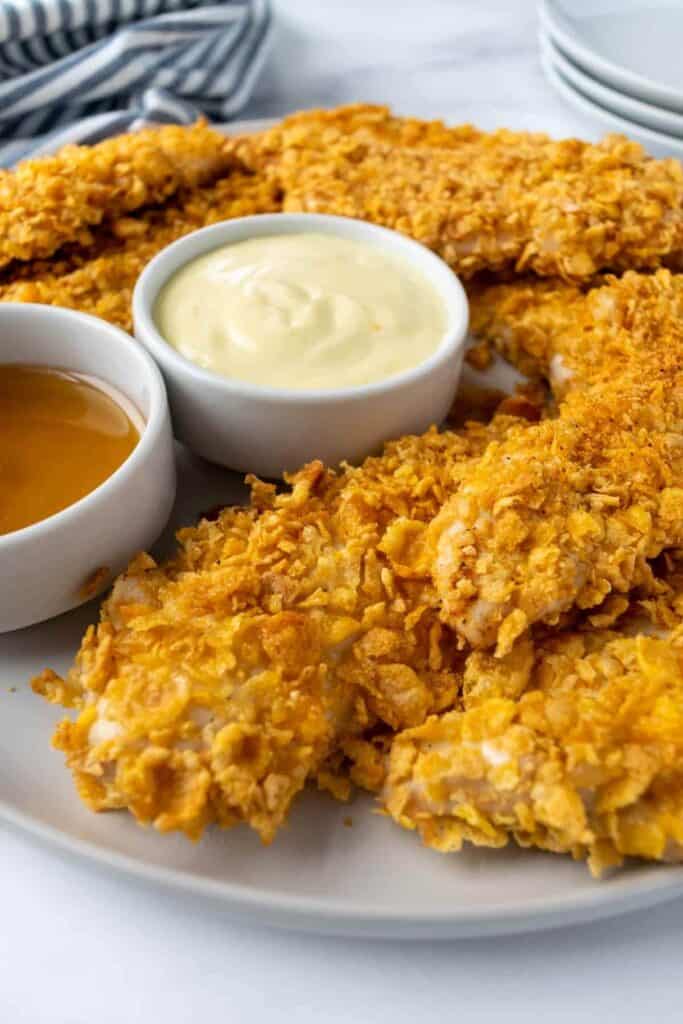 Cornflake-baked chicken tenderloins with white and honey sauce. 