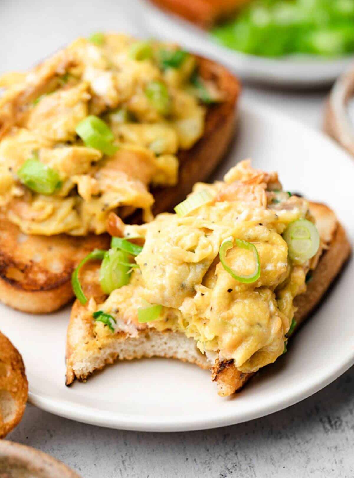 Two slices of bread with scrambled eggs with smoked salmon.