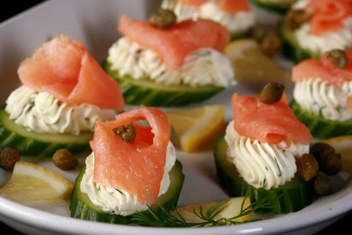 Plate with sliced cucumbers, cream and smoked salmon. 