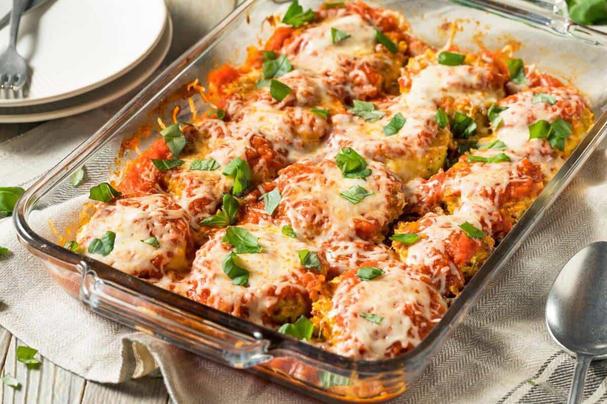 Baked eggplant parmesan in a glass dish, one of the best know foods that start with e