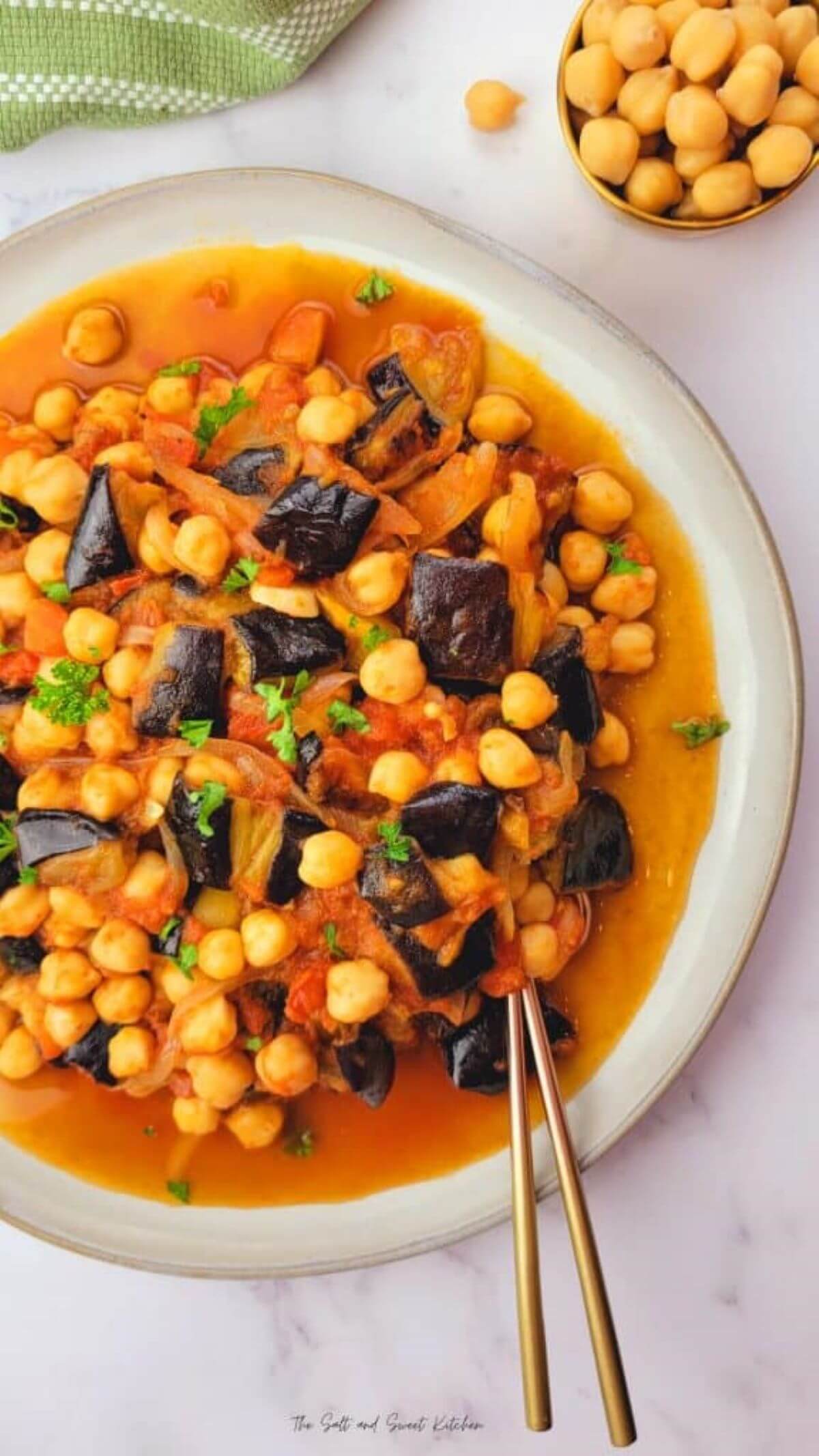 White bowl with stew and 2 spoons. 