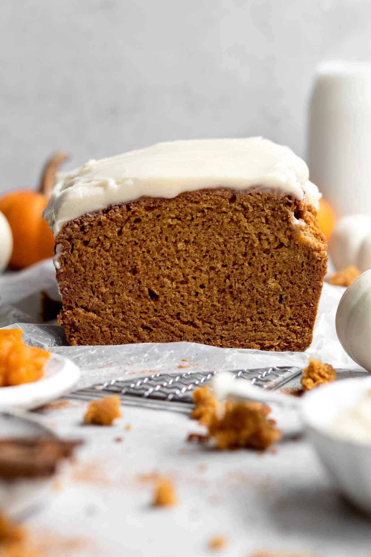 Pumpkin bread cut in the middle with cream cheese frosting. 