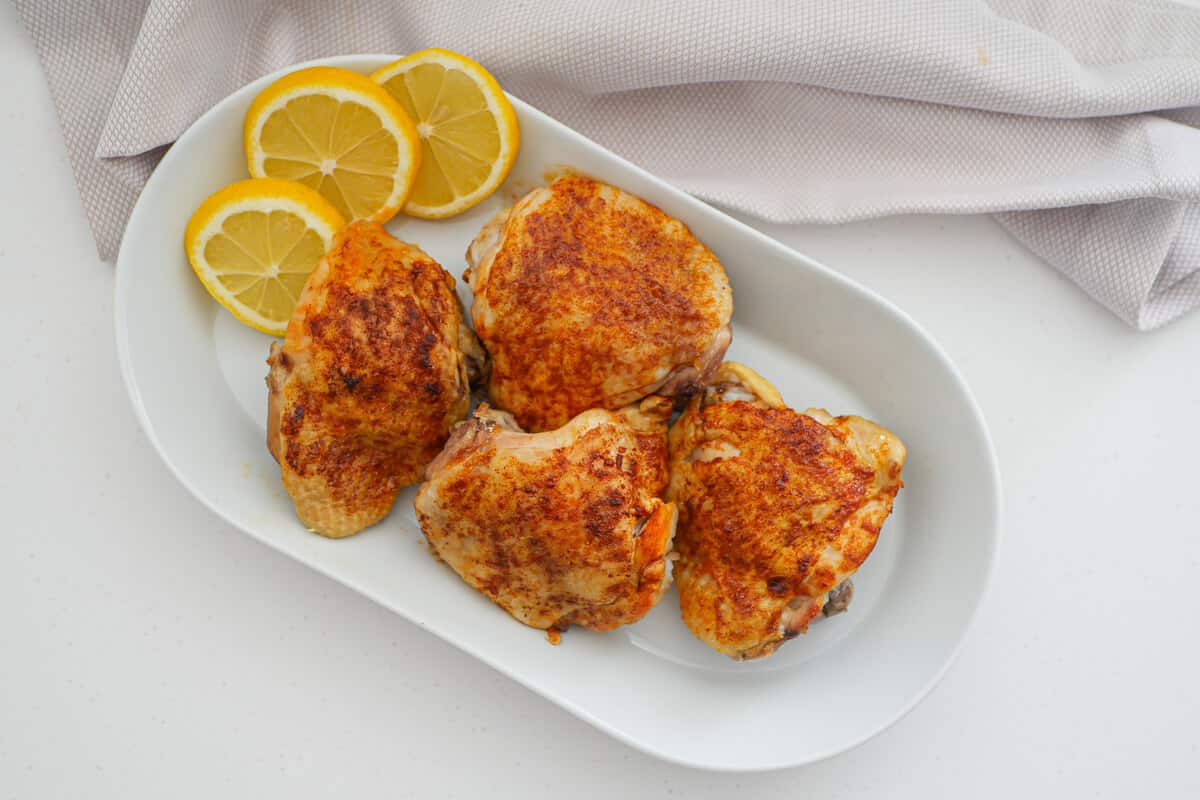 4 broiled chicken thighs on white background 