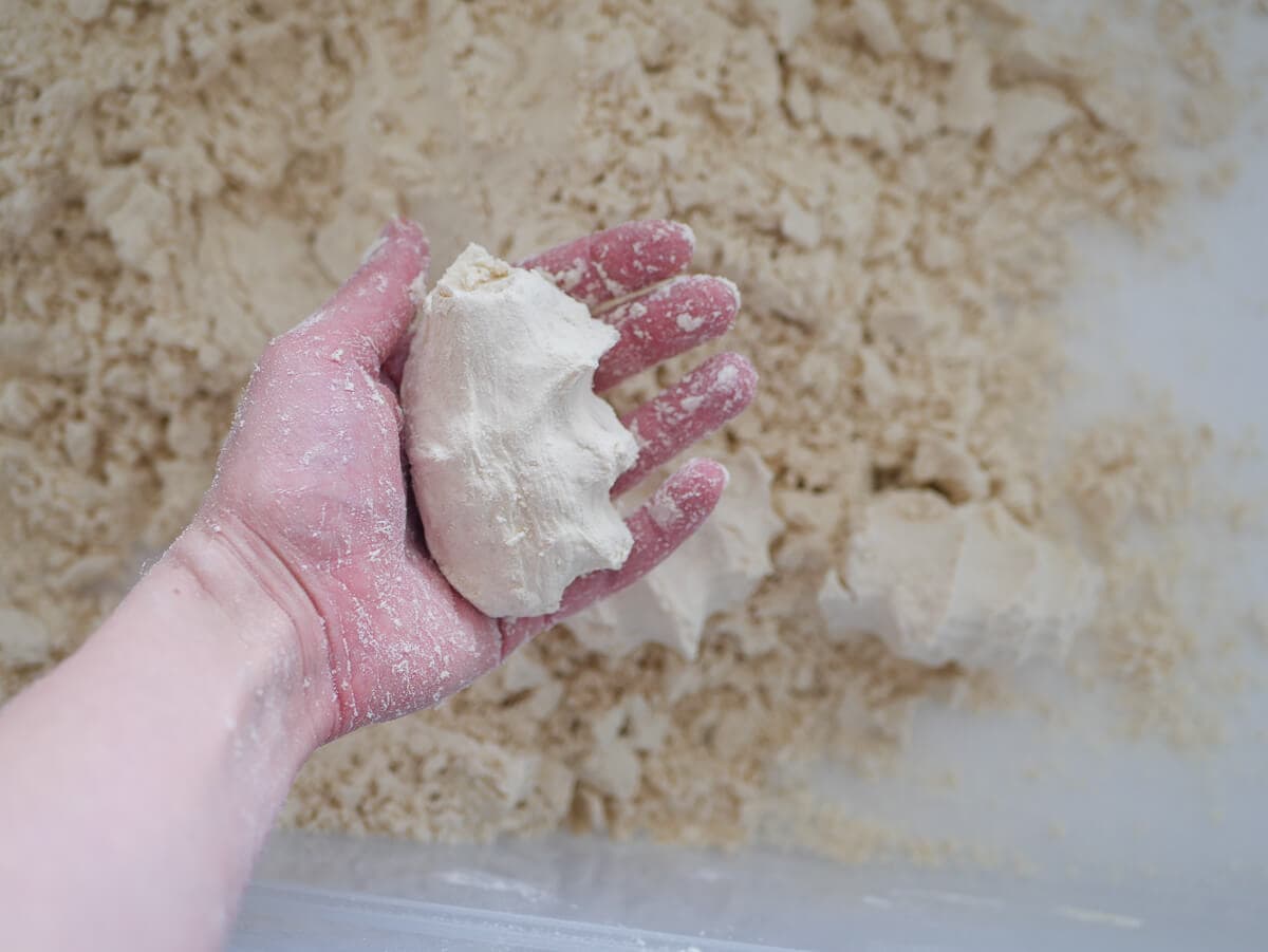 hand grabbing a chunk of homemade moon sand 