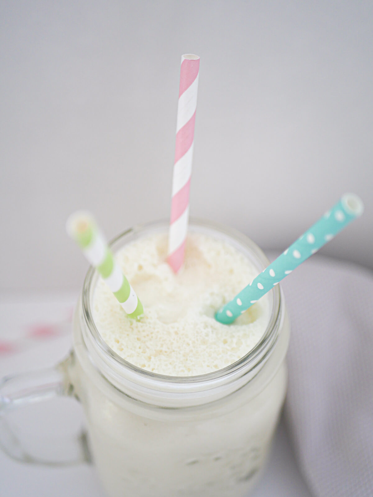 top down view of coconut shake with three straws 