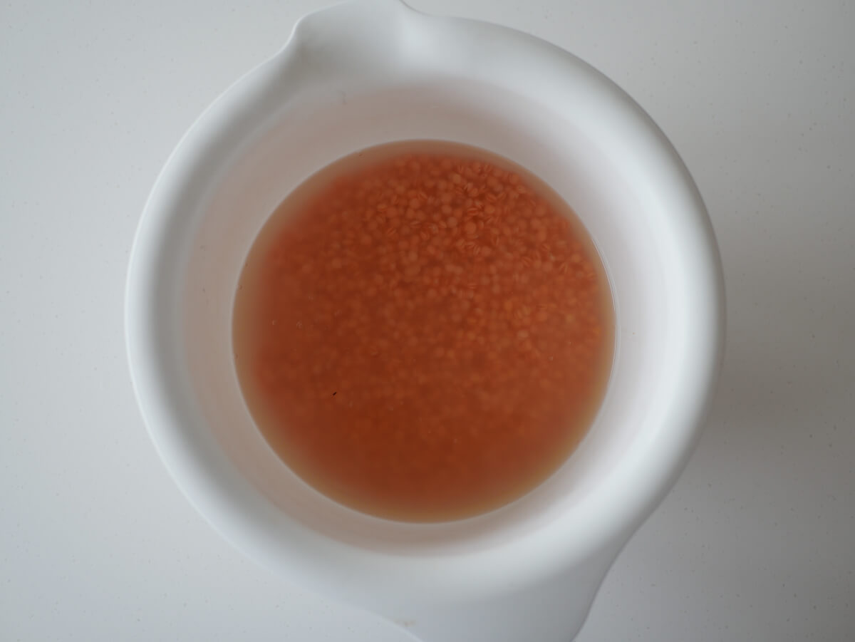 soaking red lentils in white bowl with vinegar 