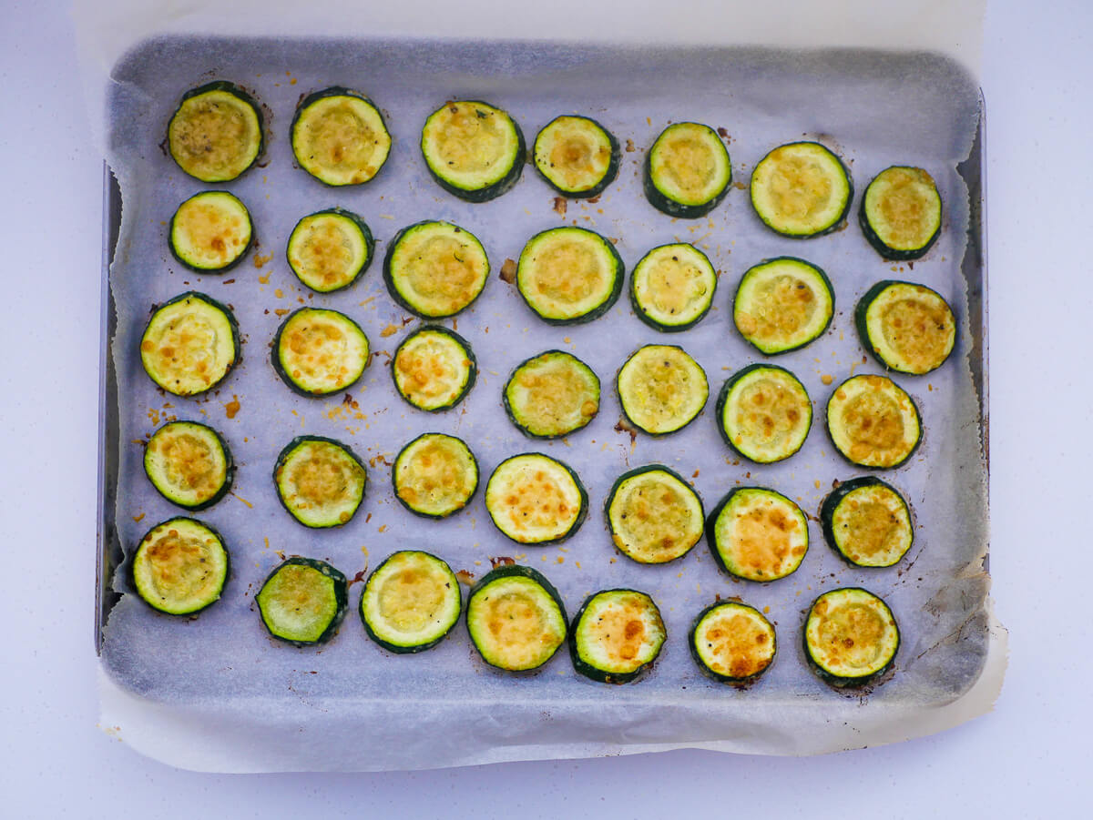 zoomed out roasted zucchini slices on a baking tray