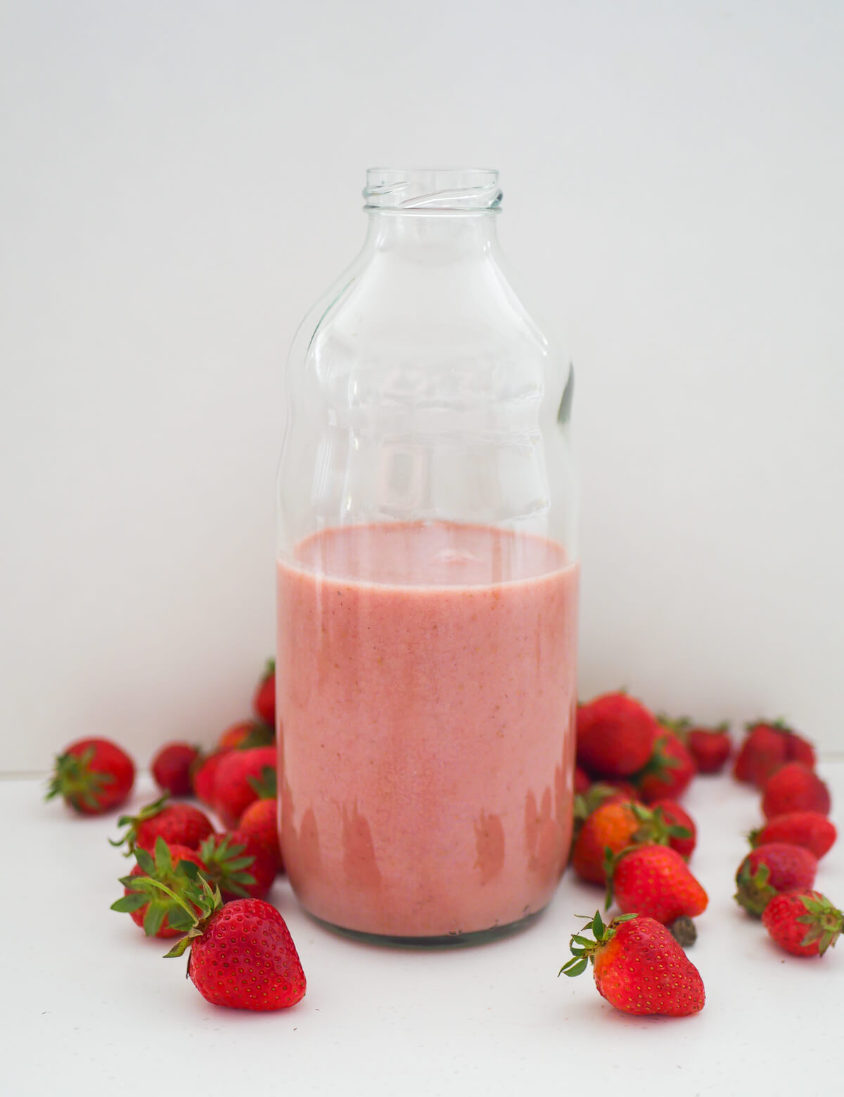 banana strawberry milkshake in a glass bottle