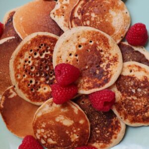 close up small pancakes without baking powder topped with raspberries