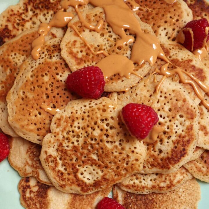 close up of fluffy pancakes topped with raspberries