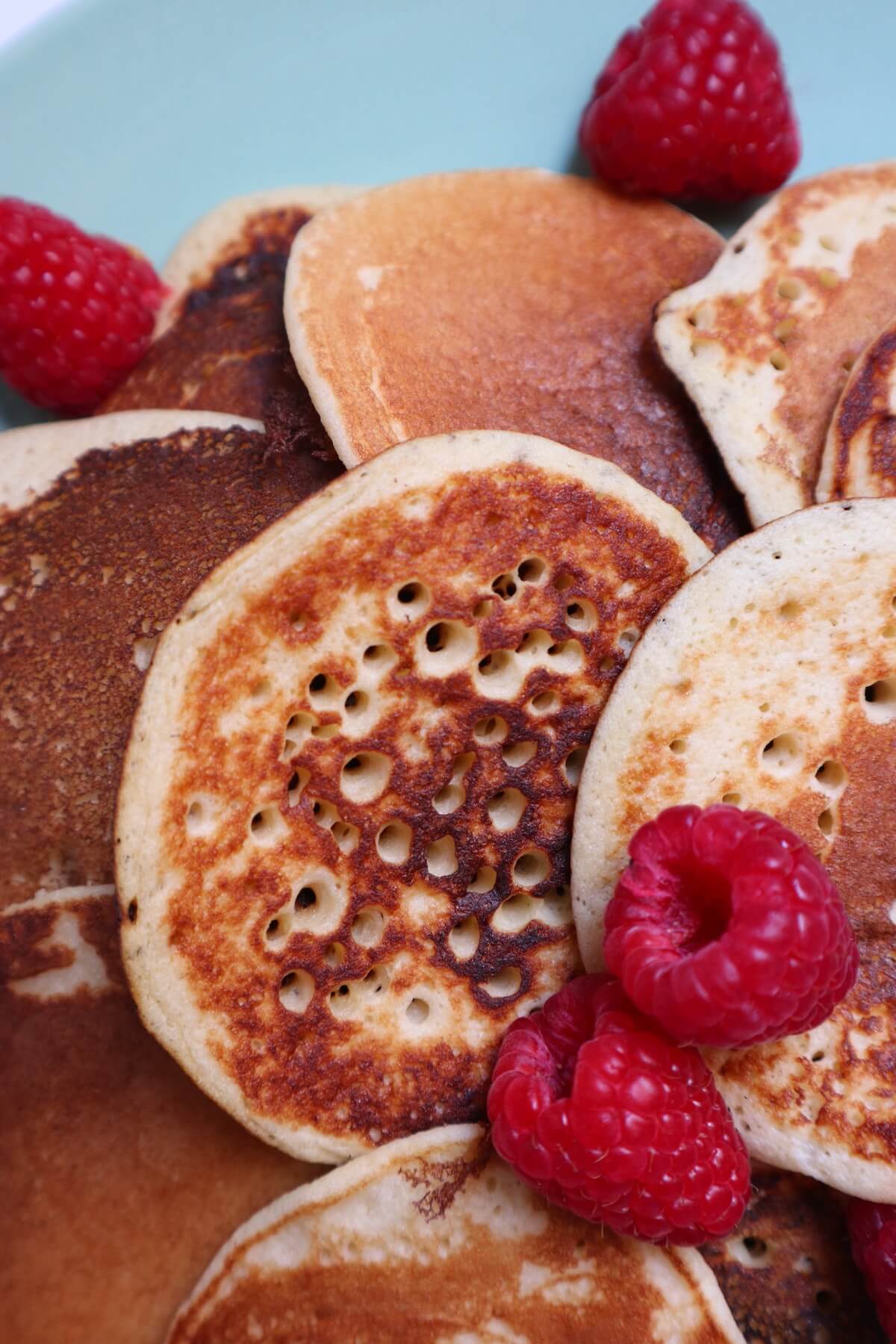 very close up shot or pancakes topped with raspberries