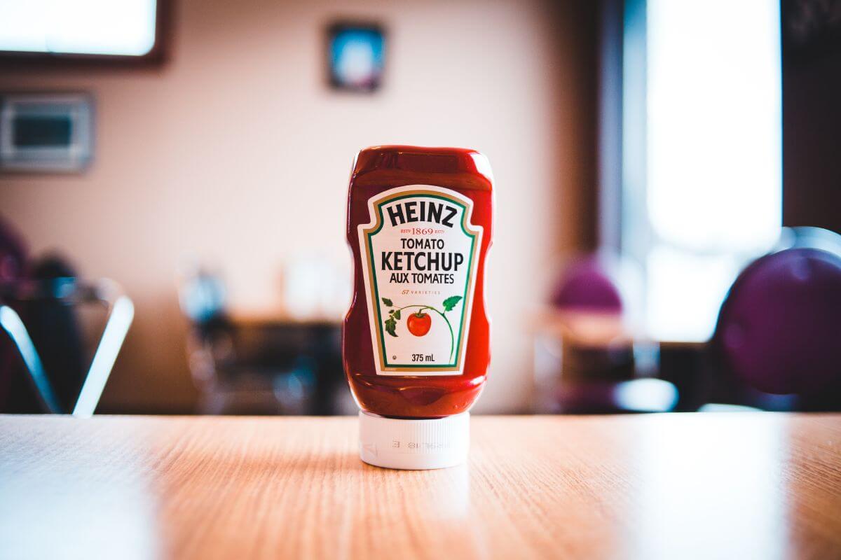 A bottle of Heinz ketchup unopened on a table, included in our list of foods that start with k