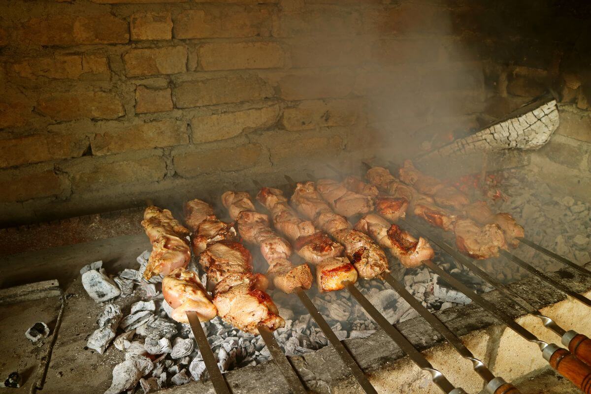 A khorovats Armenian grill with numerous skewers of meat roasting over open coals