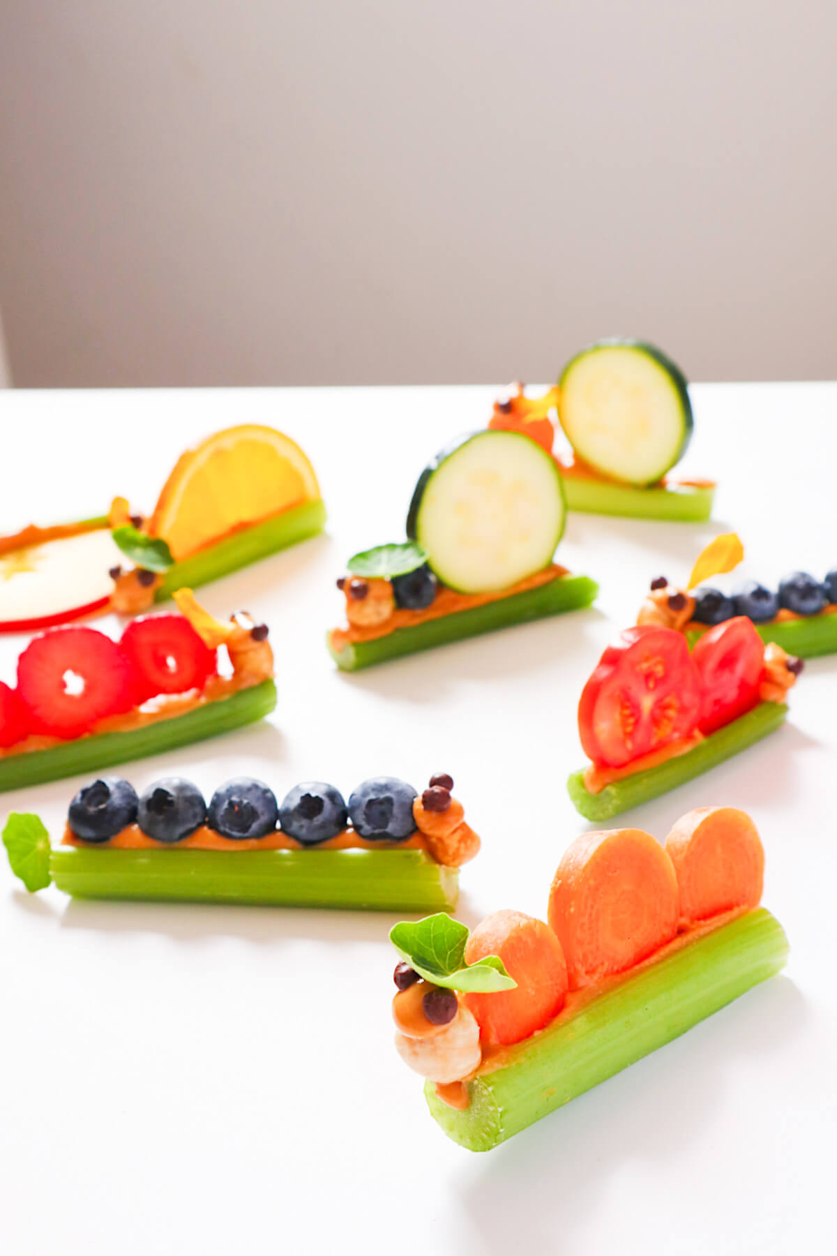 caterpillars made from celery and carrots, blueberries and tomatoes.