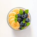 top down view of banana chia pudding topped with banana slices and bluberries