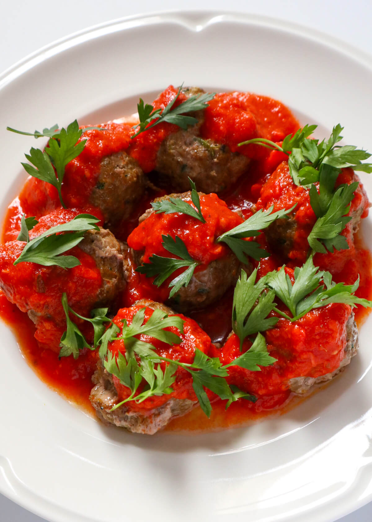 meatballs for toddler covered with marinara on a hwite plate.