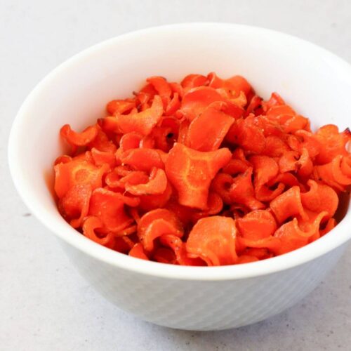 Carrot chips in a white bowl.