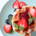 Top down view of croffle with jam and berries