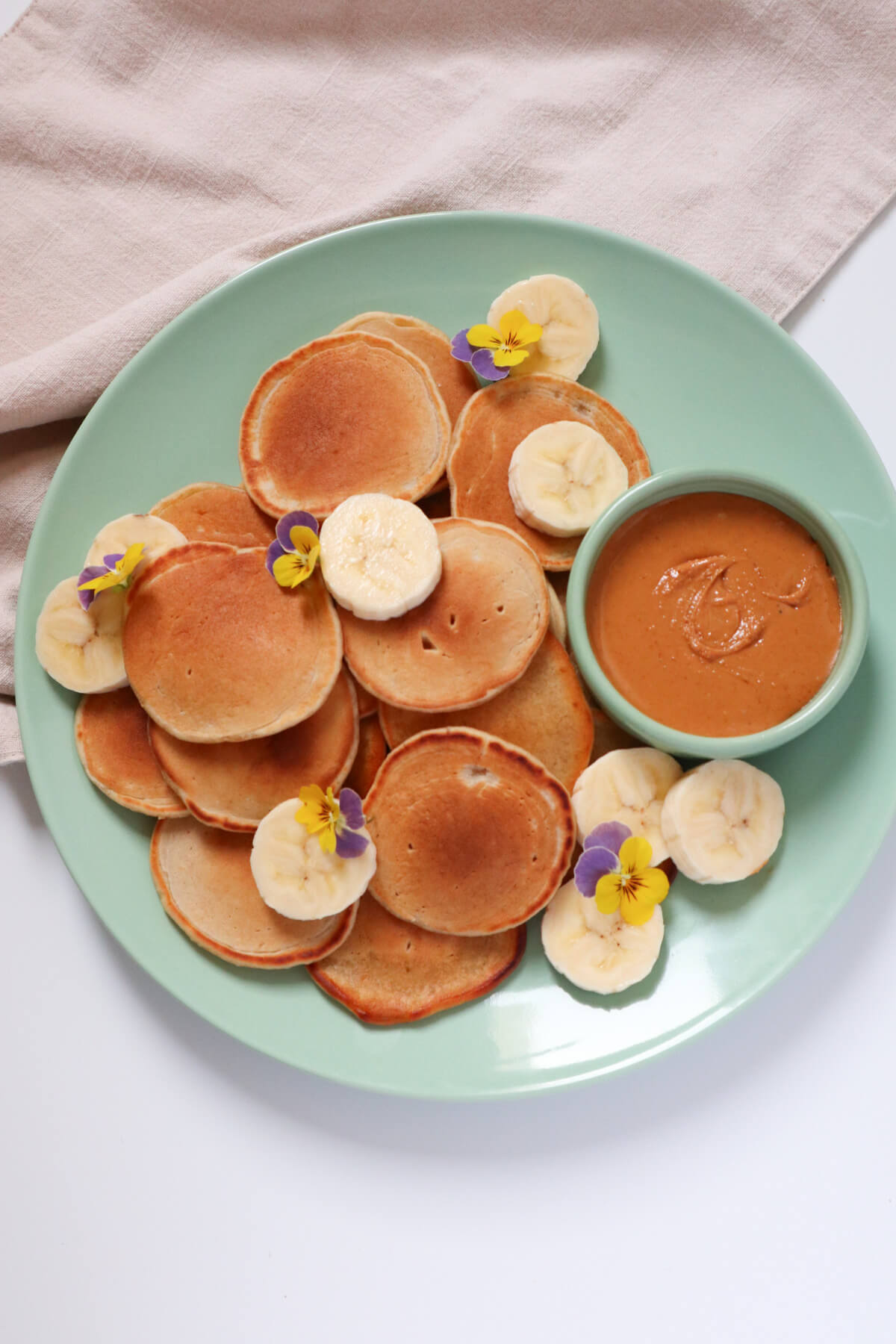 Silver dollar pancakes with peanut butter and banana slices. 
