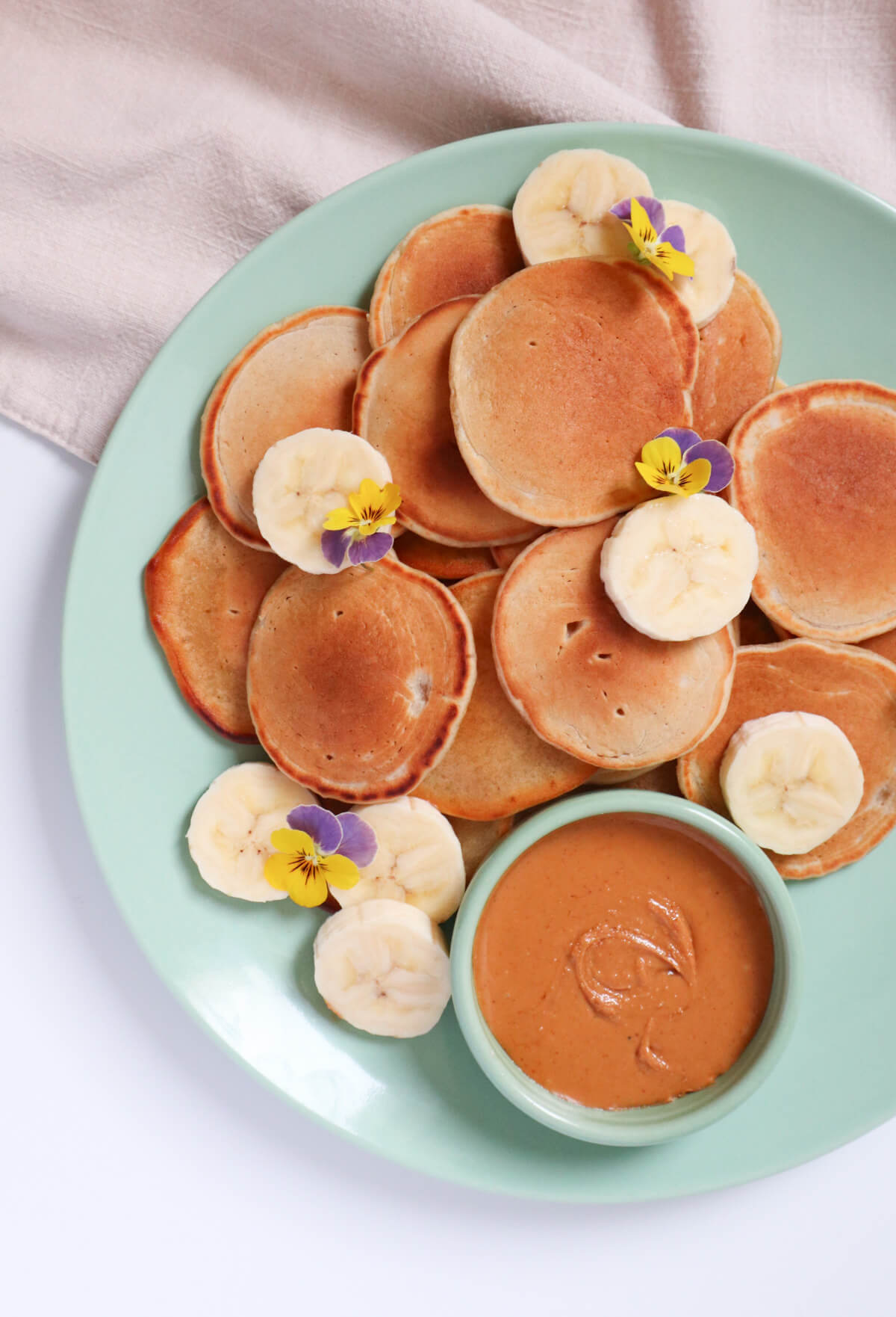 Silver dollar pancakes with peanut butter and banana slices.