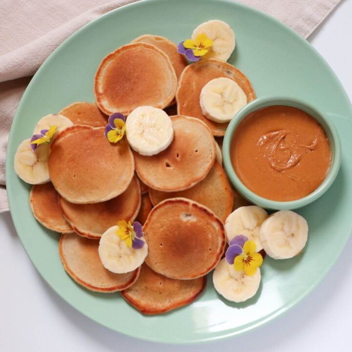 Silver dollar pancakes with peanut butter and banana slices.