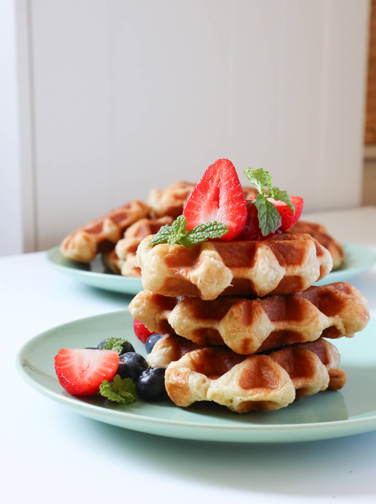Stacked croffles topped with strawberries and blueberries