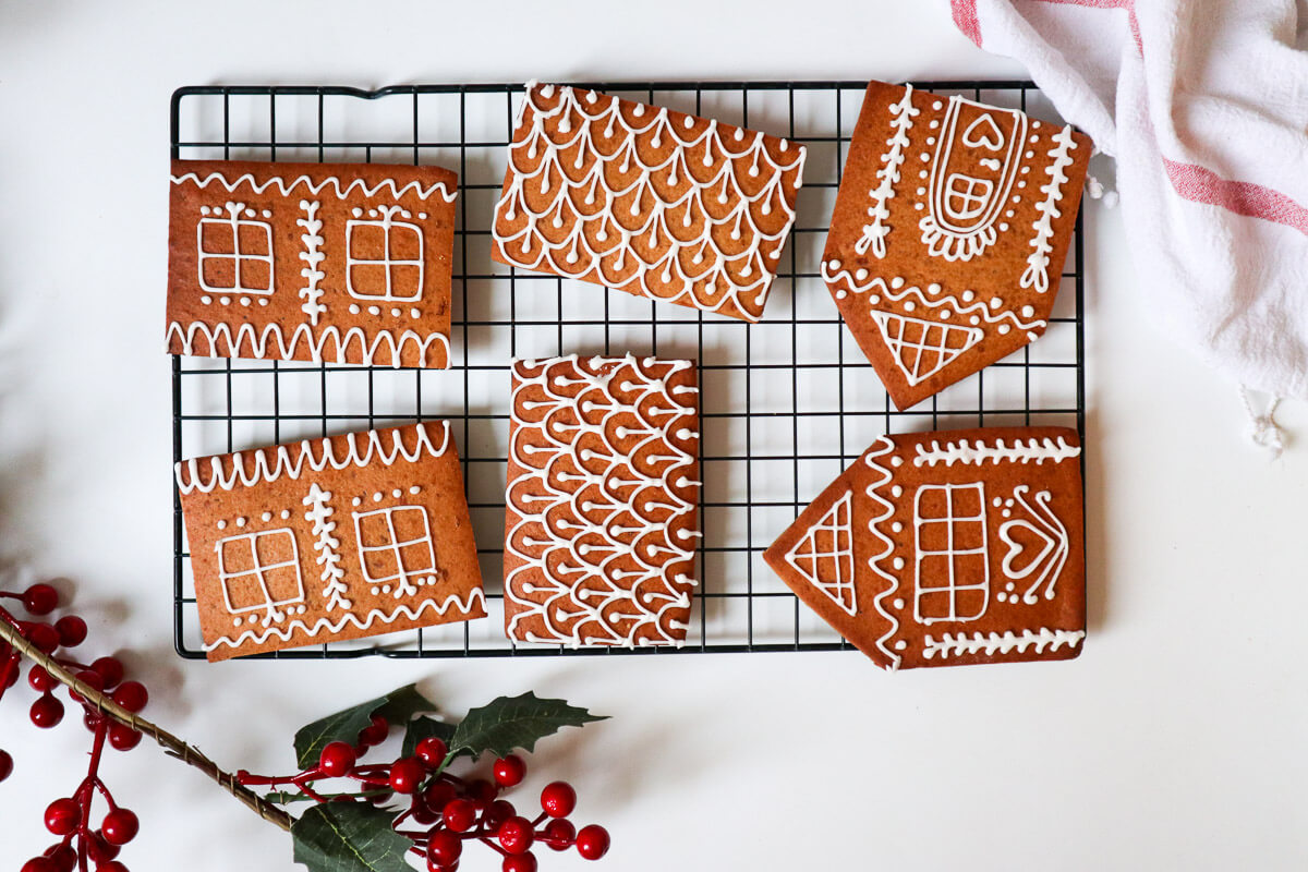 House panels decorated with royal icing on a cookie drying sheet.