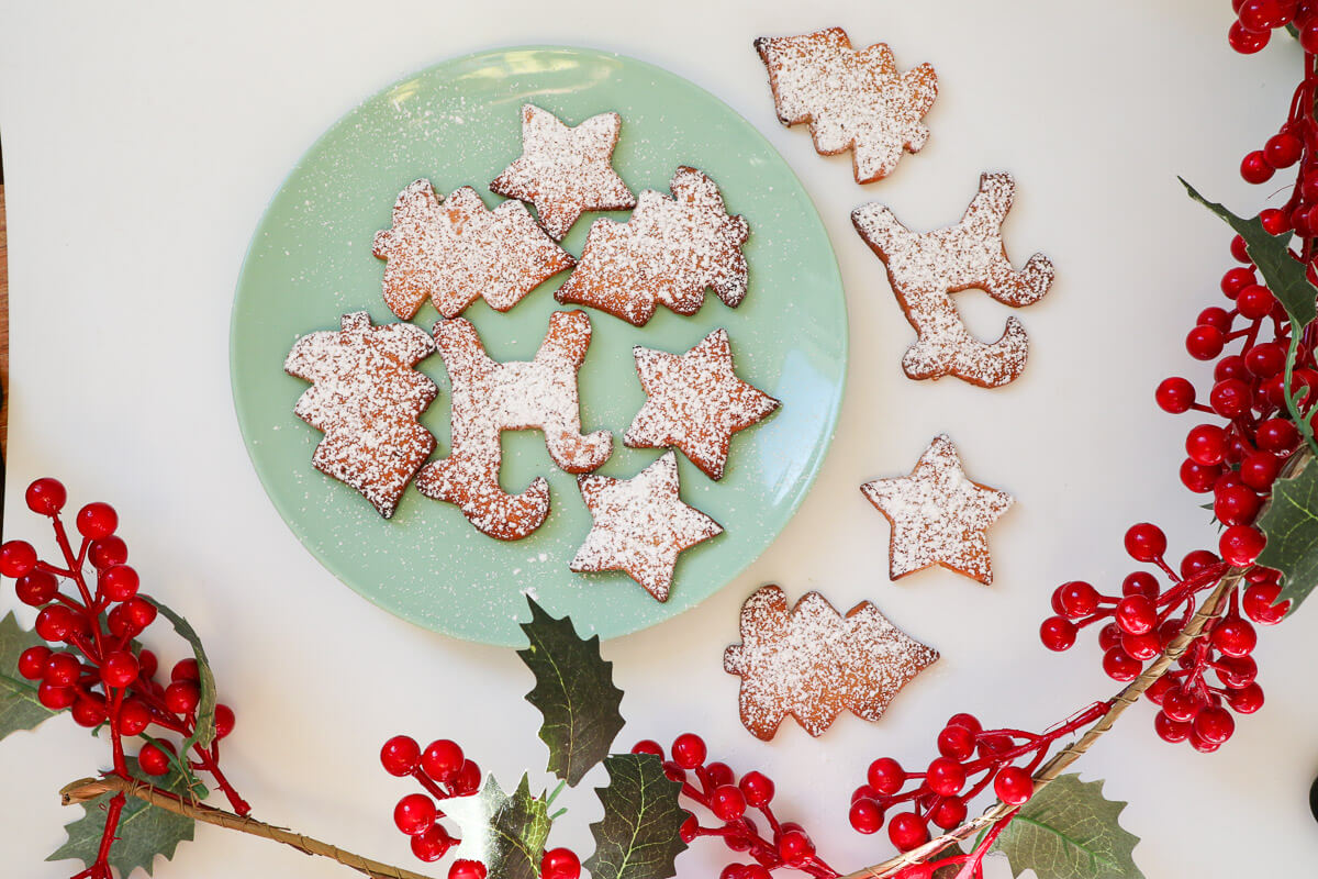 Sand tart cookies on a plate shaped in Christmas shapes. 