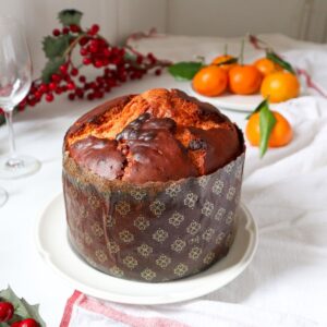 Classic Panettone with berries and mandarines in the background.