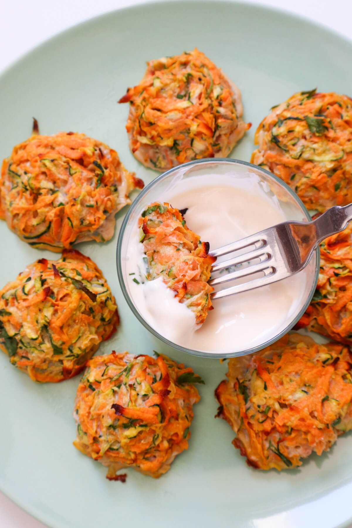 Sweet potato zucchini fritter dipped in mayo.